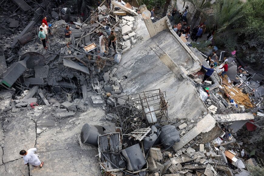 Palestinians inspect the rubble of a building, following an Israeli air strike, in Beit Lahia in the northern Gaza Strip on May 11, 2023