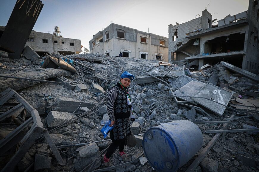 A Palestinian girl walks amid the rubble of a destroyed residential building in Deir al-Balah