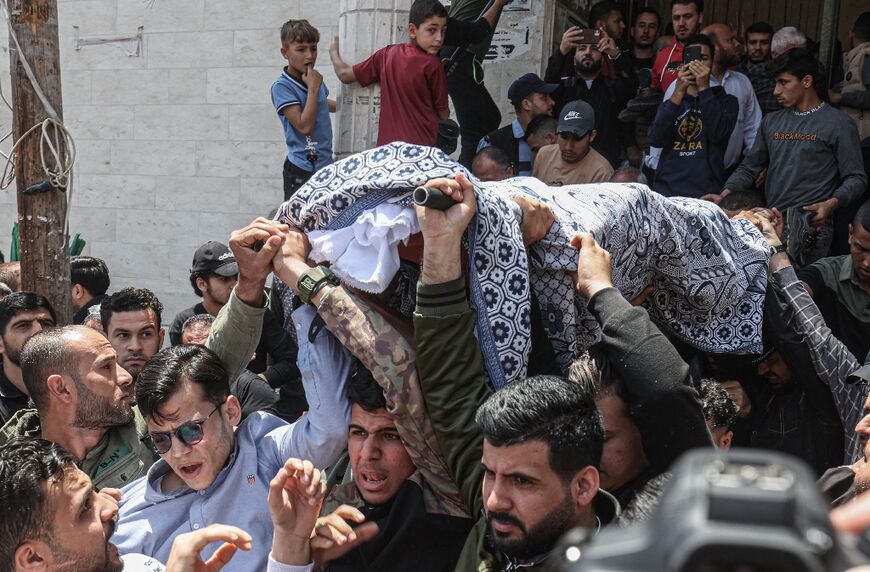 Palestinians carry the body of a man killed the previous day in Israeli military strikes, during a funeral on May 10, 2023, in Khan Yunis, in the southern Gaza Strip
