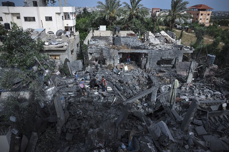 People sift through the rubble of a building hit in an Israeli air strike in Biet Hanoun, in the northern Gaza Strip on May 12