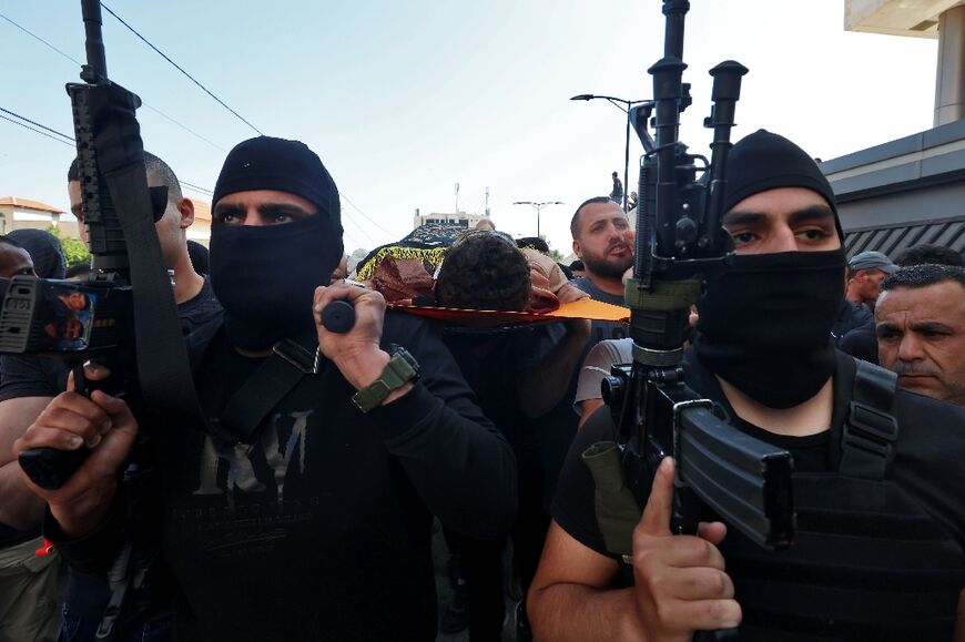 Palestinian gunmen carry a body during a funeral in Jenin in the Israeli occupied West Bank, on May 10, 2023
