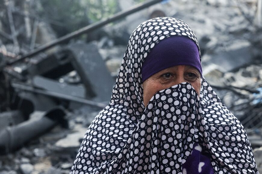 A Palestinian woman looks at the rubble of a building, following an Israeli air strike, in Beit Lahia in the northern Gaza Strip on May 11, 2023