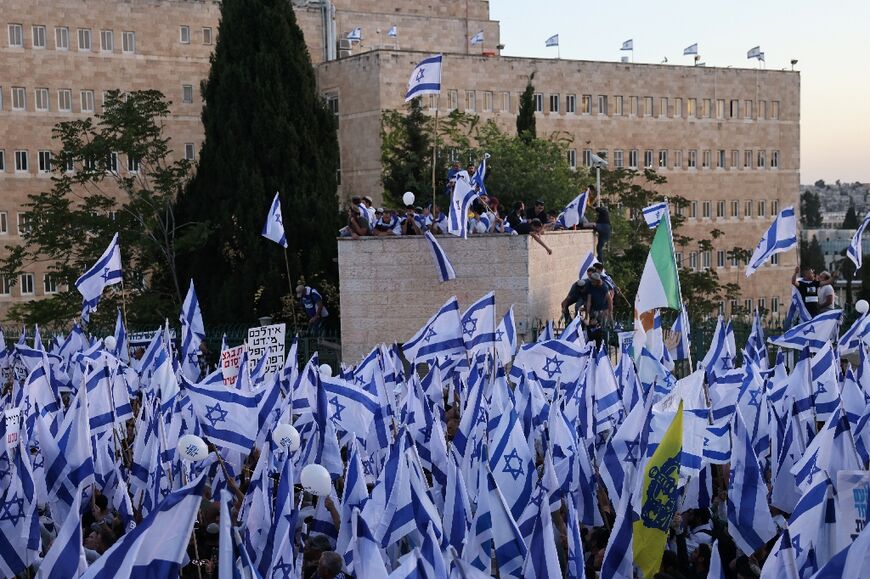 Pro-government protesters wave the Israeli flag as they gather in support of the hard-right government's controversial push to overhaul the justice system