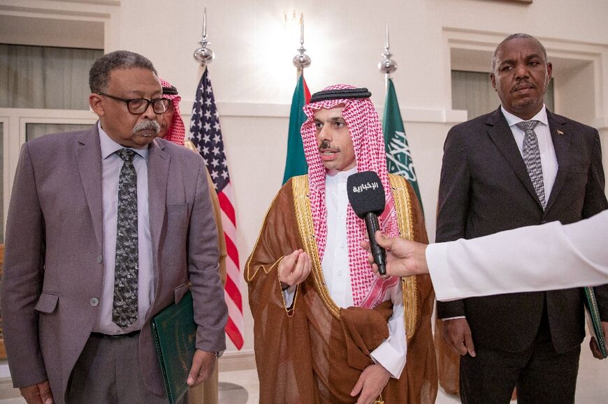 Saudi Foreign Minister Prince Faisal bin Farhan, flanked by representatives of Sudan's army and the rival Paramilitary Rapid Support forces after signing a ceasefire agreement in Jeddah