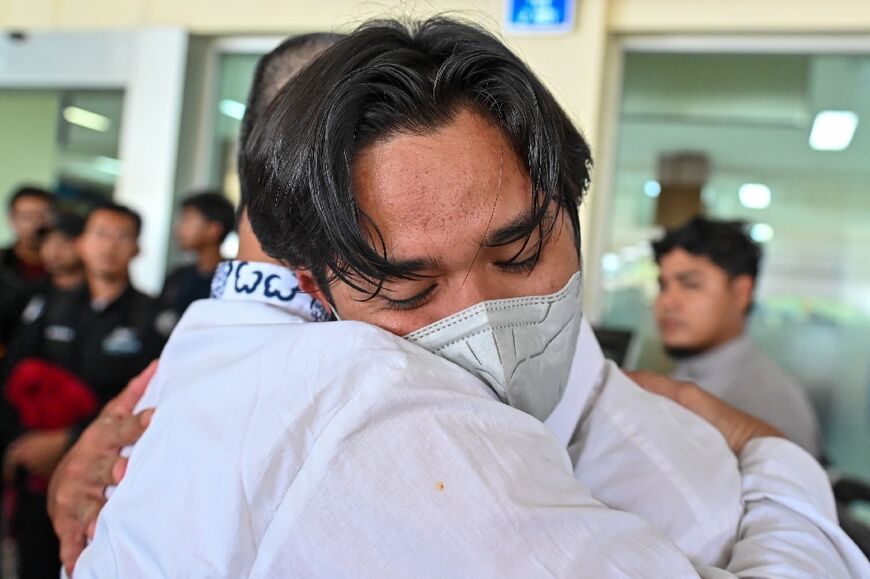 An Indonesian university student, part of a group evacuated from Sudan, is hugged by a relative on his arrival at an airport in Indonesia's Aceh province