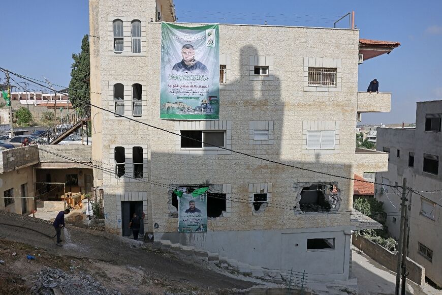Large portraits of Mutaz Khawaja hang from the side of the West Bank apartment block where he lived commemorating him as a "martyr" for the deadly shooting he carried out in Tel Aviv in March