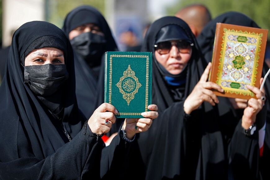 Female supporters of firebrand Shiite Muslim cleric Moqtada Sadr hold up copies of the Koran during a Baghdad protest against its desecration by a fellow Iraqi in Sweden