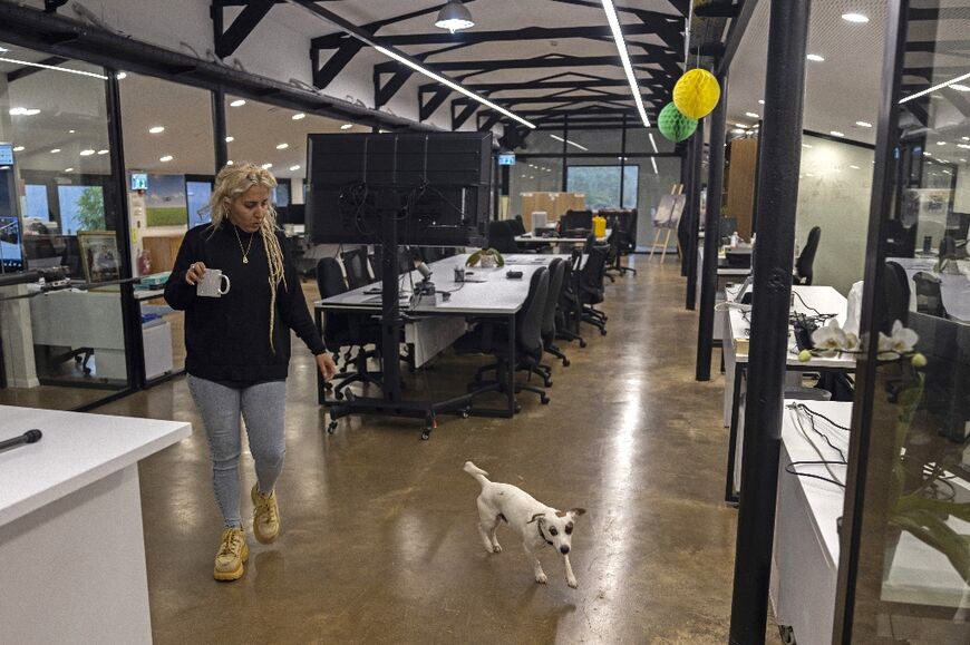 The barn's original roof and metal bars remain, but glass partitions serve as office divisions in the former stables