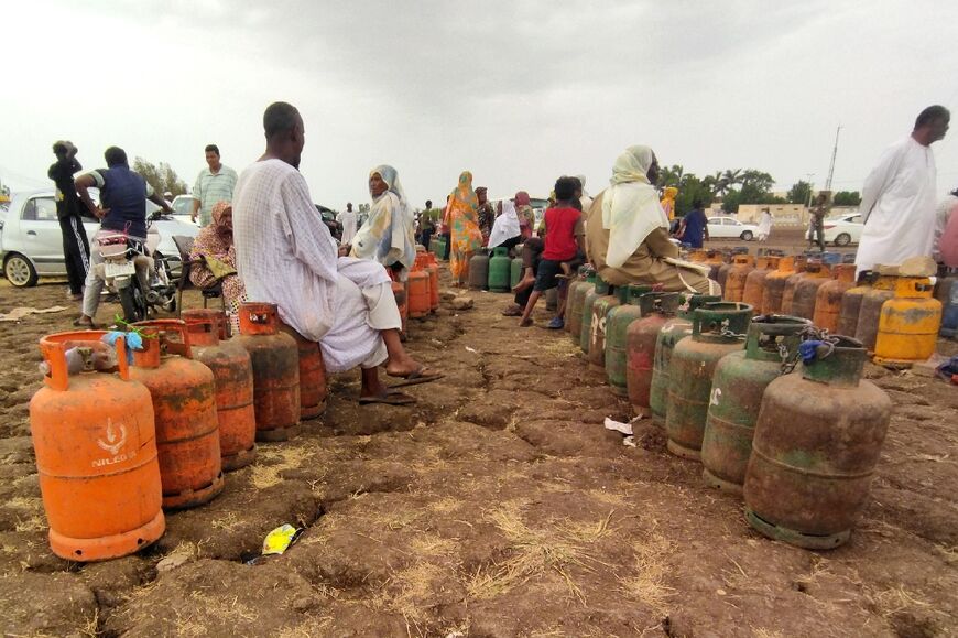 Sudanese in Wad Madani wait for a truck to arrive to exchange their empty gas canisters 