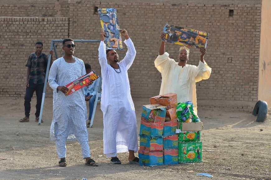 While real guns are killing people during the war, Sudanese men offer toy weapons at an Eid prayer gathering in Jazira region