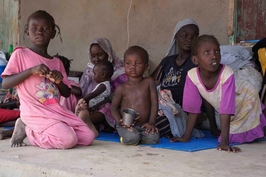 Internally displaced Sudanese with their children, pictured in a secondary school on July 10, 2023