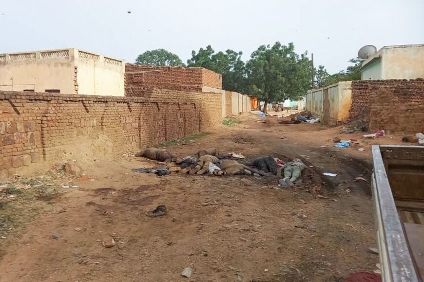 A picture taken on June 16, 2023 shows bodies strewn outdoors near houses in the West Darfur state capital El Geneina, amid ongoing fighting in war-torn Sudan