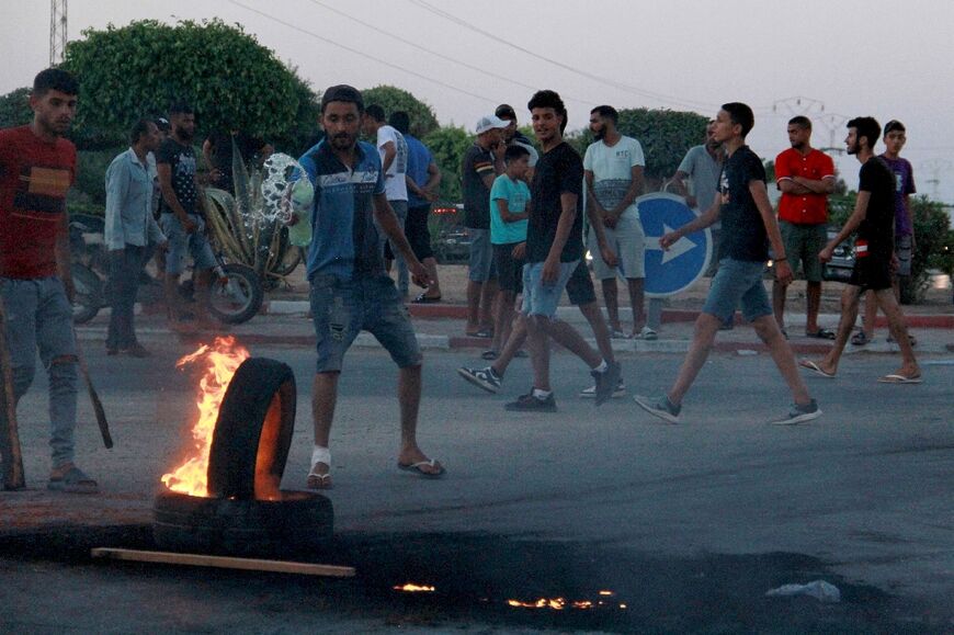 Tunisian youths block a road and set tyres on fire amid hih tensions in Sfax on July 4, 2023 after the burial of a young Tunisian stabbed to death during a scuffle between residents and migrants from sub-Saharan Africa 