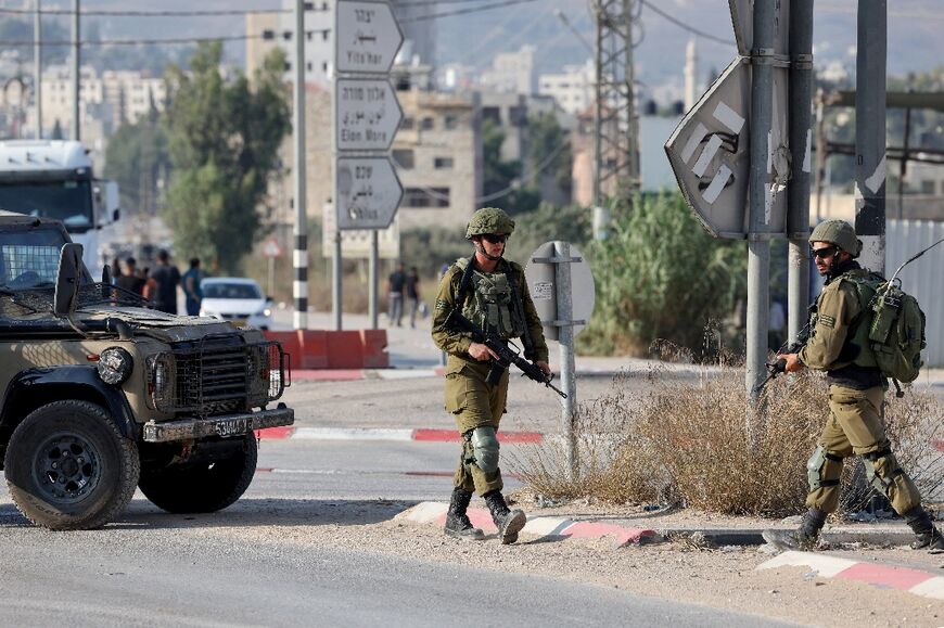 Israeli security forces block off a road in the West Bank town of Huwara as they conduct a manhunt for those reponsible for a shooting that killed two Israeli civilians