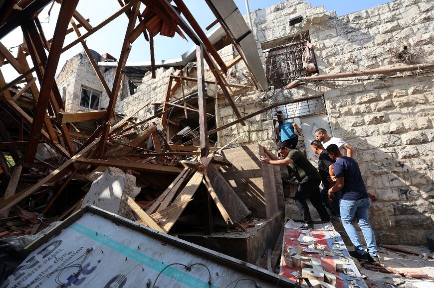 Palestinians check the damage on a house in Jenin following an Israeli military raid