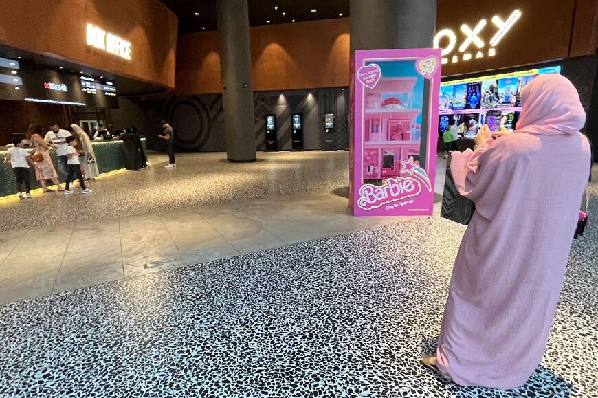 A woman in a pink abaya outside a Dubai cinema screening the movie
