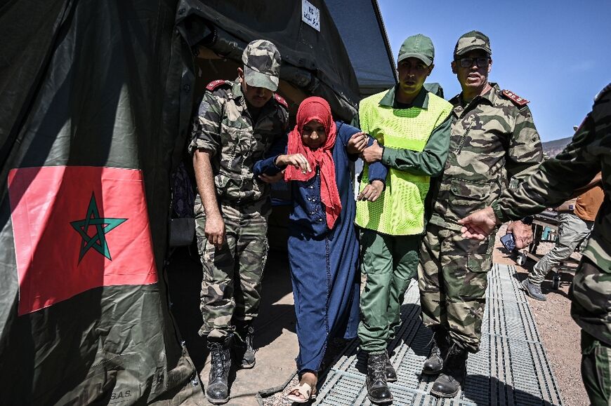Personnel attend to a survivor of Friday's earthquake at a military field hospital in the village of Asni near Moulay Brahim