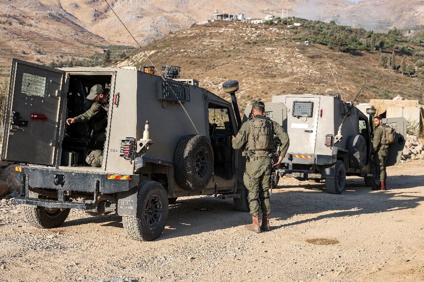 Israeli troops follow developments from the Druze village of Majdal Shams on the Israeli-occupied side of the demarcation line