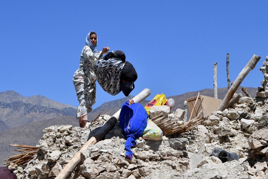 A woman salvages belongings from the rubble of her home in Missirat village, one of the most devastated in quake-hit Morocco
