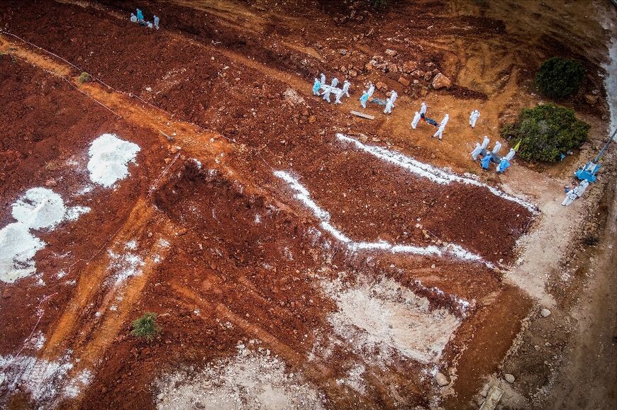Volunteers deliver bodies of flood victims to a mass grave south of Libya's eastern city of Derna