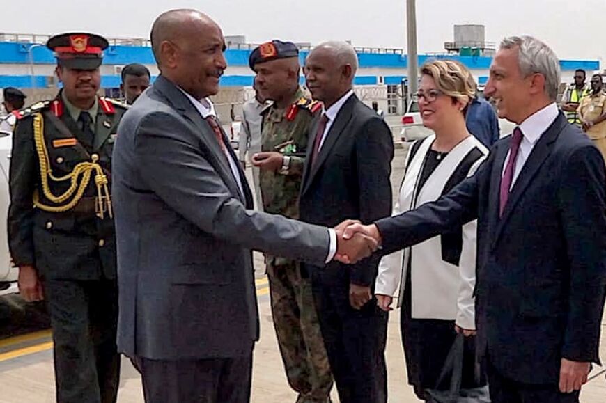 Sudan's army chief General Abdel Fattah al-Burhan (2nd-L) shaking hands with officials prior to departure from Port Sudan International Airport for a visit to Turkey, his latest foreign stop