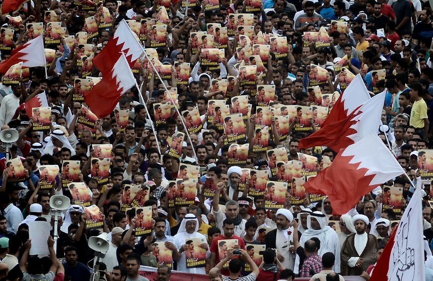 Bahraini Shiite demonstrators holding posters of Abdulhadi al-Khawaja during a protest in 2012
