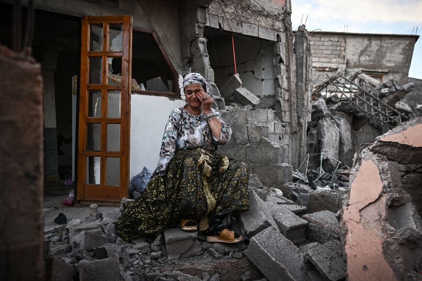 A survivor of the deadly 6.8-magnitude September 8 earthquake amid the rubble of her damaged house, in the mountain village of Moulay Brahim in al-Haouz province in central Morocco 