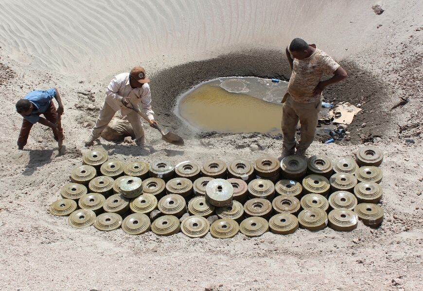 Yemeni demining experts prepare for a controlled explosion to destroy explosives and mines laid by Huthi rebels, on April 5, 2016 in the southern city of Aden