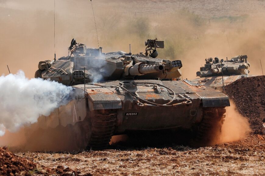 Israeli Merkava tanks take part in a military drill near the border with Lebanon in the upper Galilee region of northern Israel on October 24, 2023 amid increasing cross-border fire between Hezbollah and Israel