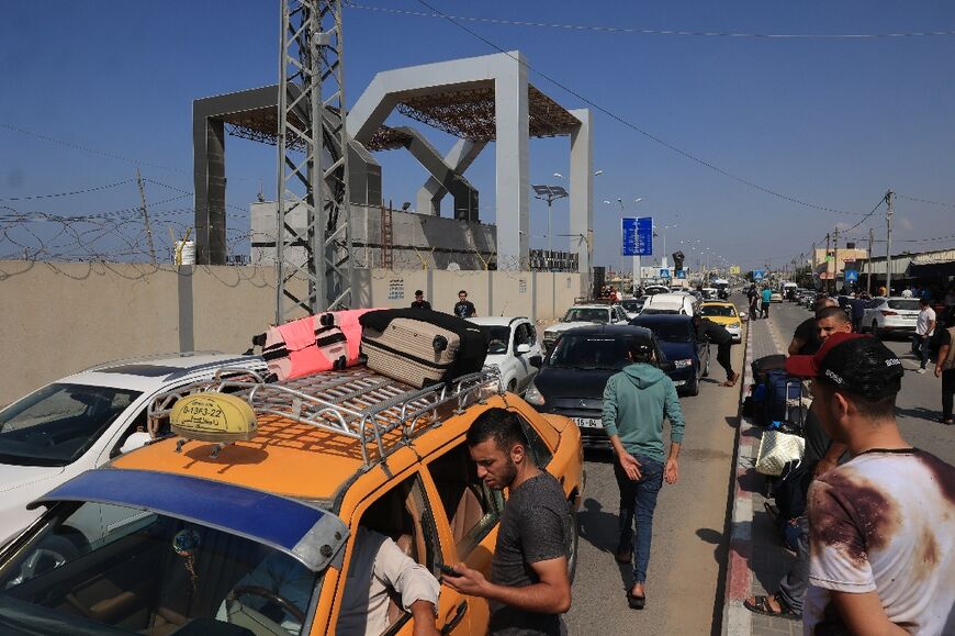 Palestinians with foreign passports arrive at the Rafah gate hoping to cross into Egypt