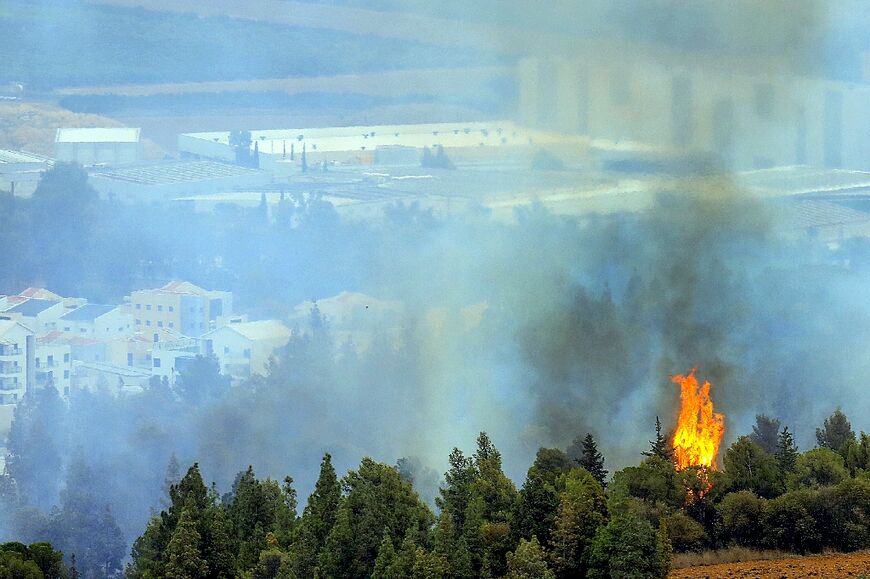 A picture taken from southern Lebanon near the border with Israel shows smoke rising near the northern Israeli Kibbutz of Kfar Giladi on October 30, 2023 after Lebanese shelling amid increasing cross-border tensions