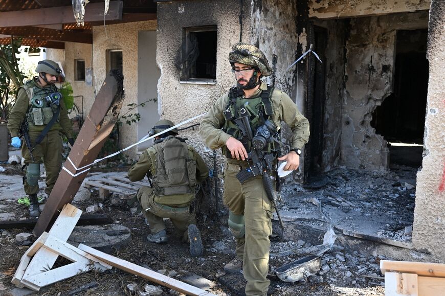 Israeli soldiers cordon off an area in Kibbutz Beeri near the border with the Gaza Strip on October 15, 2023, more than a week after the attack by Palestinian militants