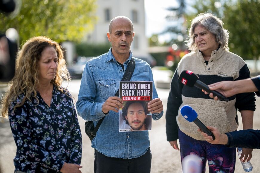 Relatives of  Israelis missing or held hostages by the Hamas (From L) Doris Liber representing her son Guy Iluz, Assaf Shem Tov, showing a picture of his 21-year-old nephew Omer Shem Tov and Michal Dorset representing her niece  Romi Gonen