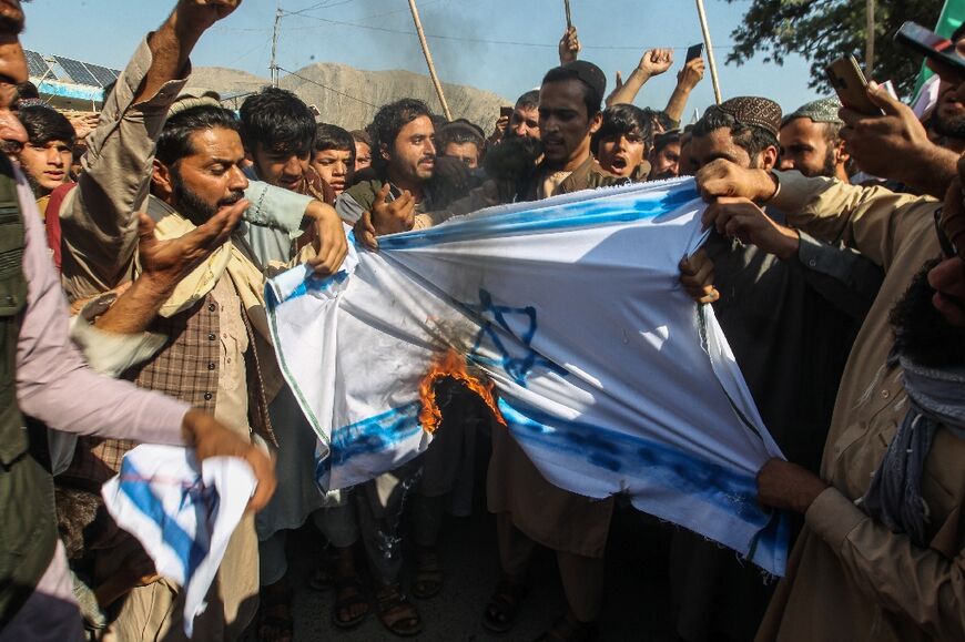 Afghan protesters burn a flag of Israel at a demonstration