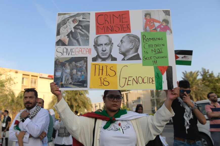 Bahrainis carry placards during a gathering in Manama, to express their solidarity with the Palestinian people during Israel's bombardment of Gaza