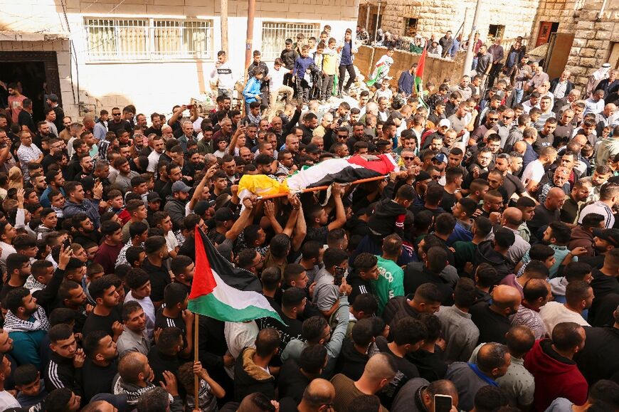 Mourners carry the body Mohammed Melhim, who was killed in clashes with Israeli forces, during his funeral in the village of Halhul north of the city of Hebron in the occupied West Bank on October 17, 2023
