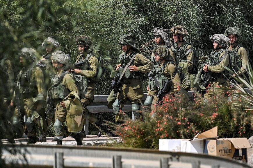 Israeli army soldiers at a checkpoint near the border with the Gaza Strip in Israel's southern city of Sderot on October 12, 2023