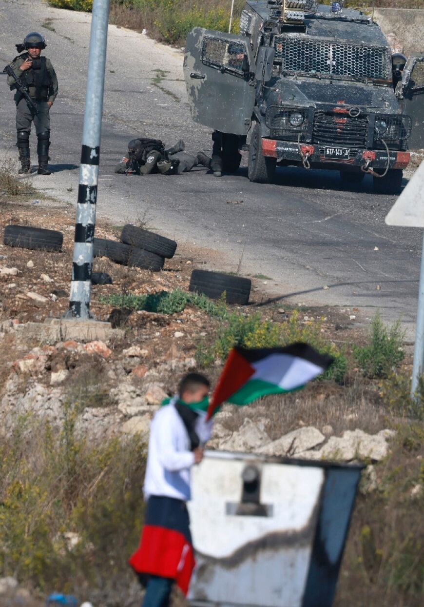 Israeli forces take position amid clashes with Palestinian protesters at the northern entrance of Ramallah city, near the Beit El Israeli settlement, in the occupied West Bank on October 16, 2023