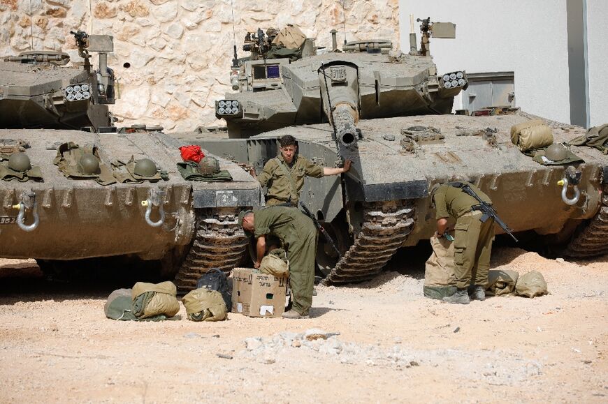 Israeli soldiers with Merkava tanks at an undisclosed location on the border with Lebanon on October 22, 2023