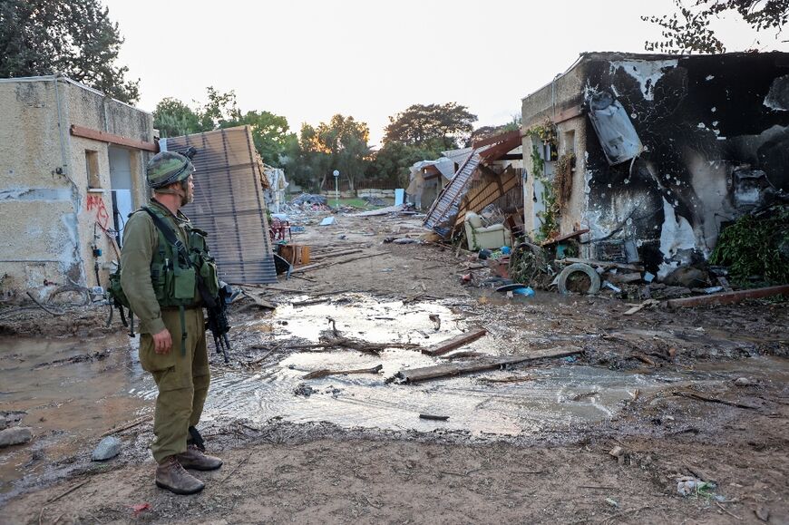 Israeli troops search the scene of a Palestinian militant attack in the Israeli kibbutz of Kfar Aza on the border with the Gaza Strip on October 11, 2023