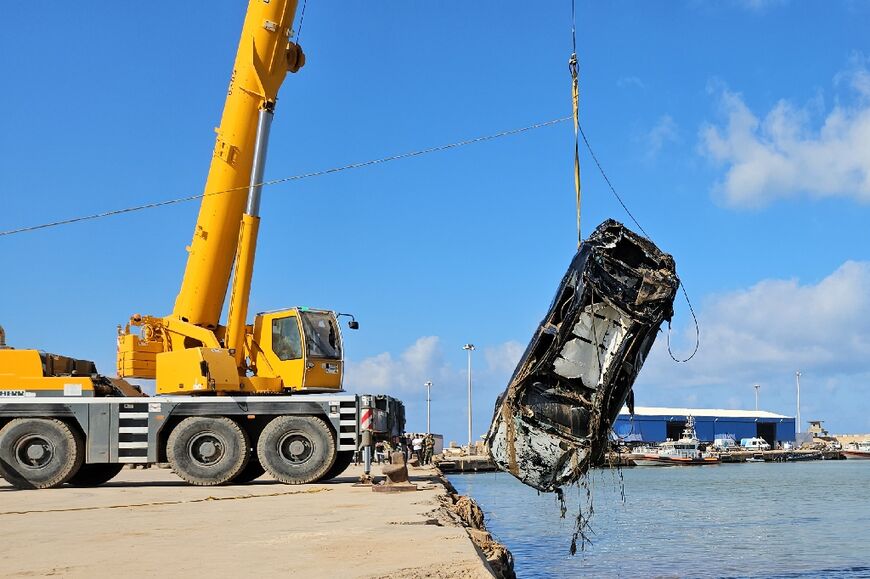 A car that was washed into the sea during the flood is pulled out after being found by Emirati divers