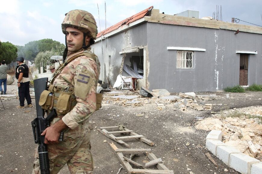 A Lebanese soldier stands outside a house damaged by Israeli shelling on the outskirts of the southern Lebanese border village of Dhayra on Wednesday