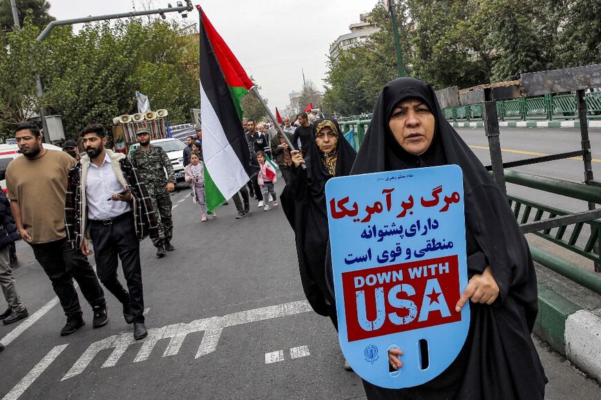 A woman in Tehran holds a 'Down with USA' sign during an anti-Israel rally