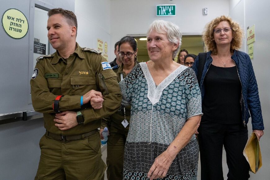 This handout picture released by the Israeli army, courtesy of the hostages' families, shows former captive Margalit Moses escorted by a soldier into a hospital in Israel