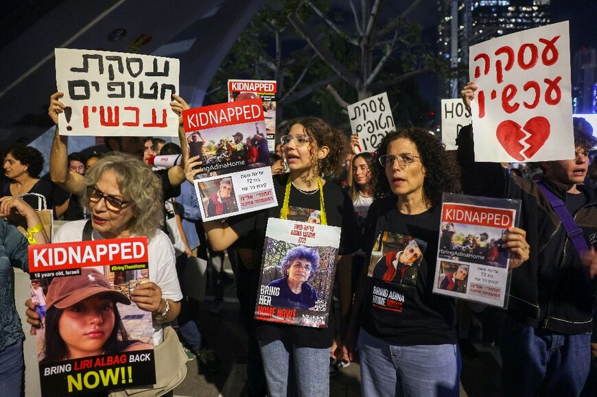 Relatives and supporters of hostages held in Gaza since Hamas's October 7 attack on Israel hold placards and images of those taken, during a demonstration outside the defence ministry in Tel AViv calling for a deal to be made by the Israeli government for their release, on November 15, 2023.
