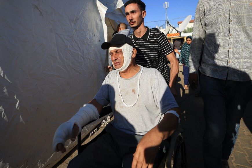 A wounded Palestinian man is wheeled outside Al-Aqsa hospital at Deir al-Balah, in central Gaza