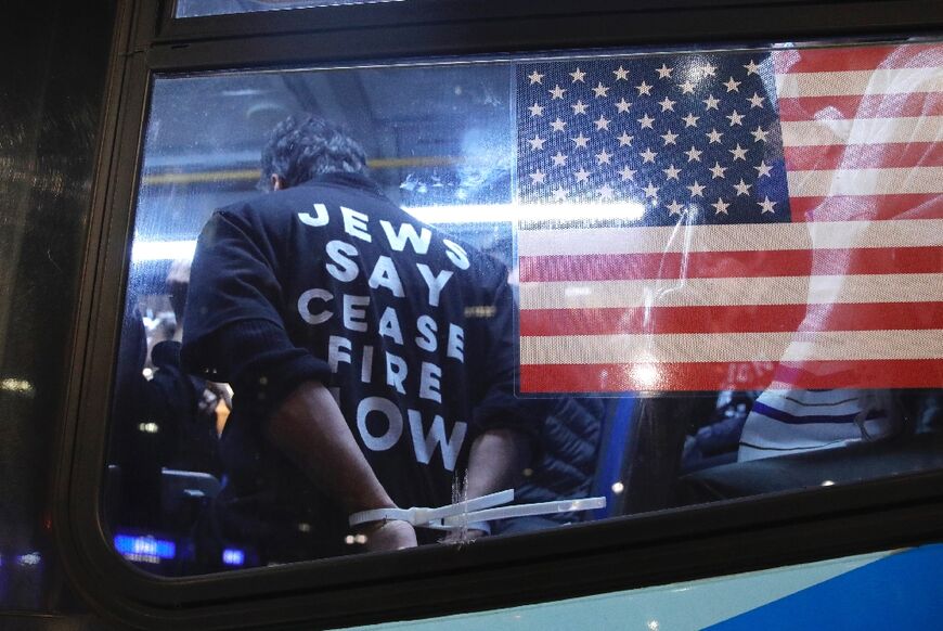 Cuffed protesters arrested during a demonstration calling for a ceasefire amid war between Israel and Hamas, are transported by NYPD at Grand Central Station in New York City on October 27, 2023