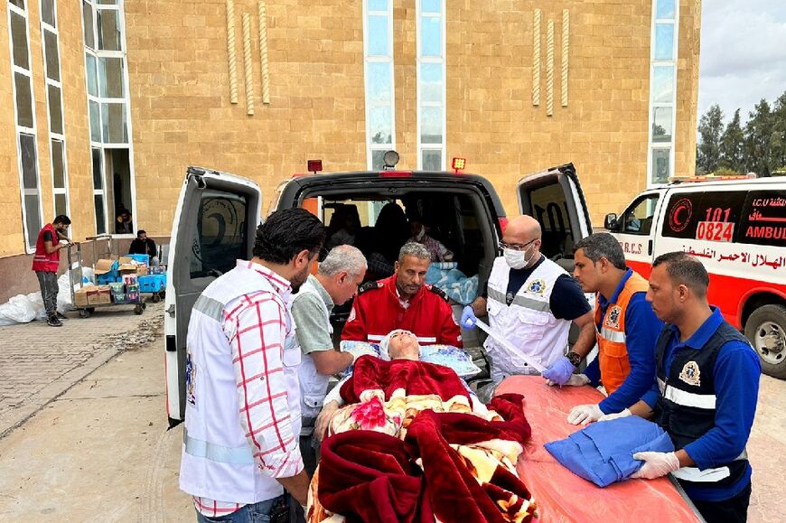 Paramedics transfer a wounded Palestinian upon arrival from Gaza to the Egyptian side of the Rafah border crossing with the Palestinian territory