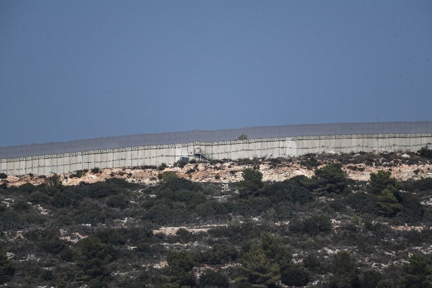 Below the UN-patrolled border, where a wall snakes along a ridge, Israeli soldiers sit camouflaged among the vegetation