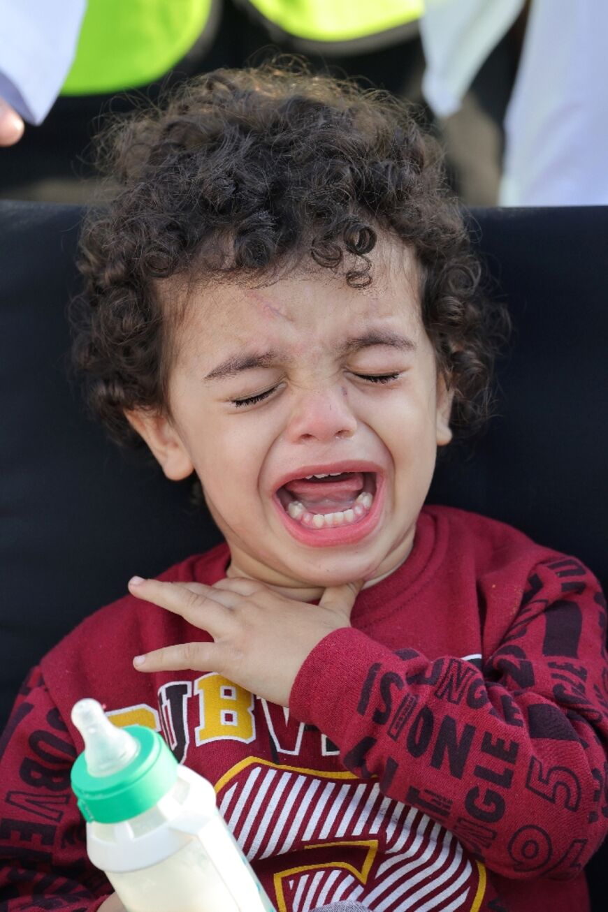 A wounded Palestinian child cries upon arrival in Abu Dhabi after being evacuated from Gaza